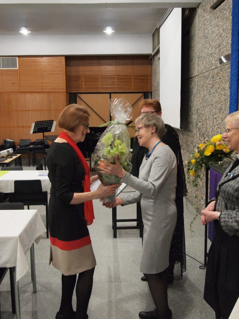 Kukkia vastaanottamassa Leena Vaasto. Taustalla Hannele Nykänen, kukkia ojentamassa Anneli Sikanen ja oikealla Irja Eskelinen.